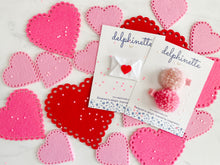 Load image into Gallery viewer, delphinette handmade felt little girl/baby girl hair accessory - a little carnation pink yarn pom pom and a light rose pink yarn pom pom that can be customized as a hair clip, headband or hair tie. Handmade in Canada.