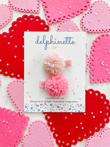 delphinette handmade felt little girl/baby girl hair accessory - a little carnation pink yarn pom pom and a light rose pink yarn pom pom that can be customized as a hair clip, headband or hair tie. Handmade in Canada. 