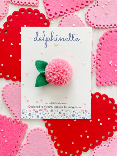 delphinette handmade felt little girl/baby girl hair accessory - a little carnation pink yarn pom pom flower that can be customized as a hair clip, headband or hair tie. Handmade in Canada.